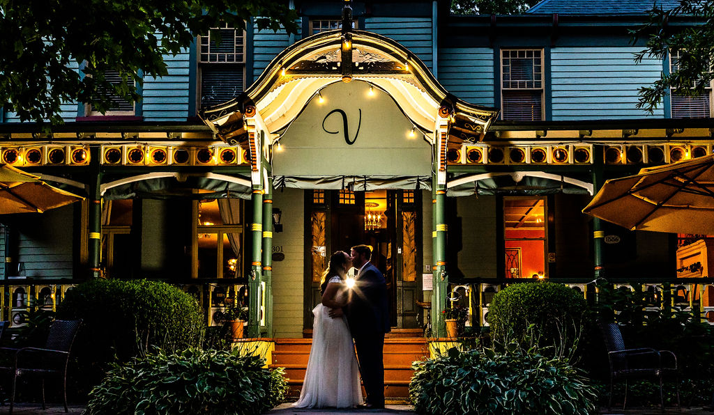 Couple poses outside of Vandiver Inn for a night shot